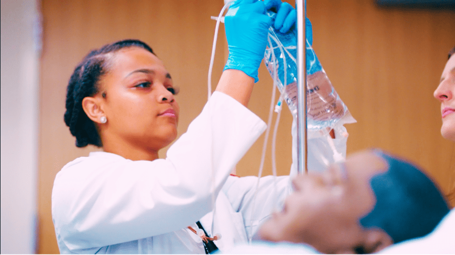 Nursing student adjusting the IV.