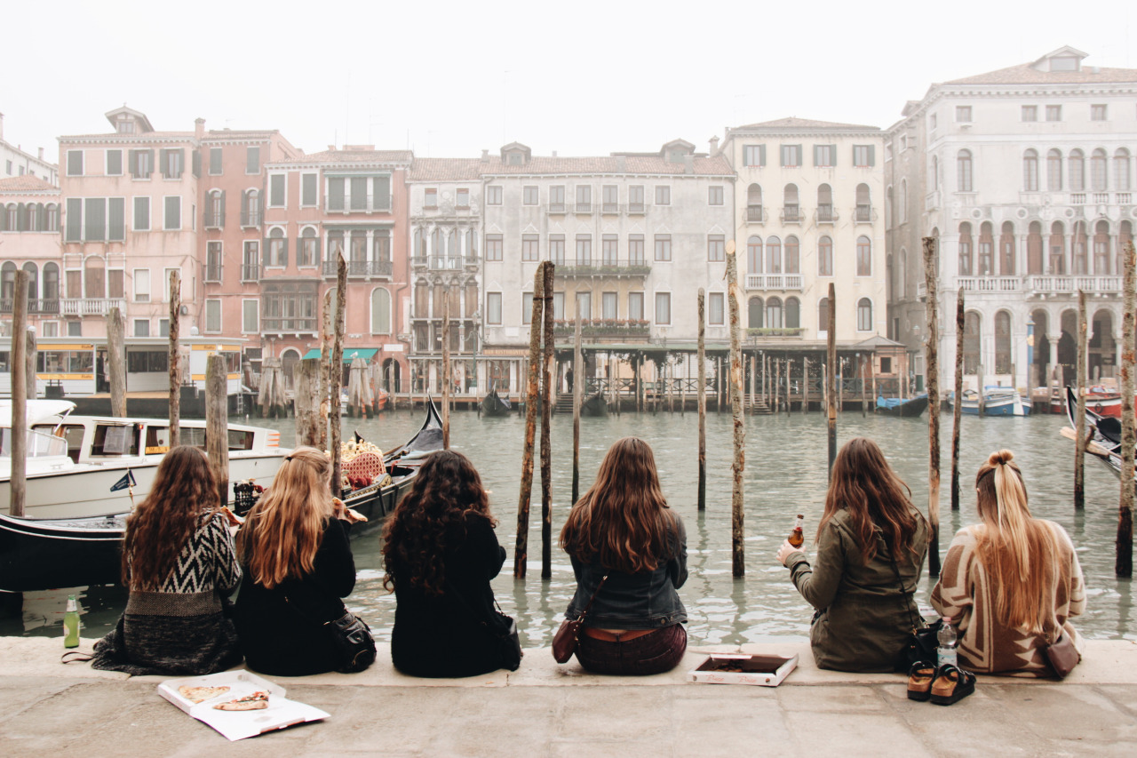 Female students sitting by water in Europe
